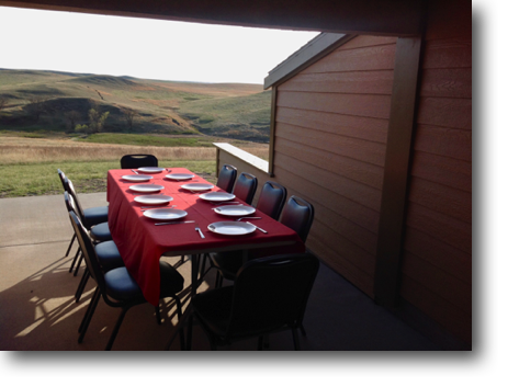 The table is set for supper outdoors on the patio.
