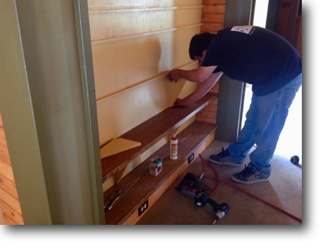 Corey installing shelves in the library.