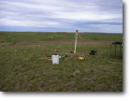 Survey equipment with graded site in the background.